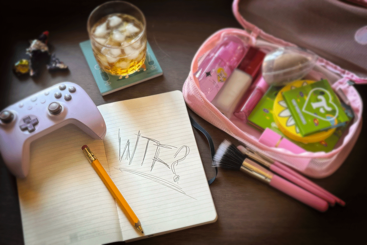 A messy desk scene with a notebook reading “WTF?” alongside a controller, drink, makeup bag, and candy.